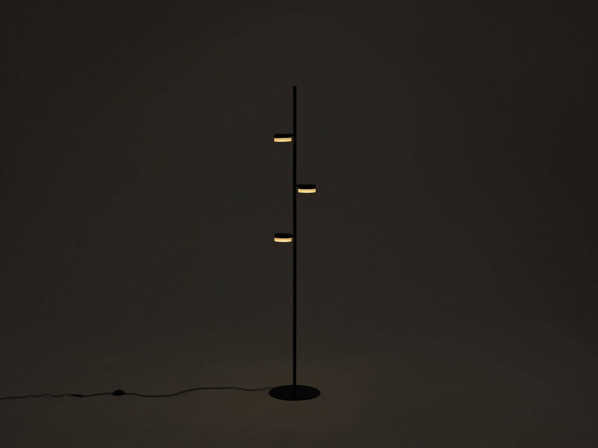 The Row living room floor lamp in a dark room with lights on